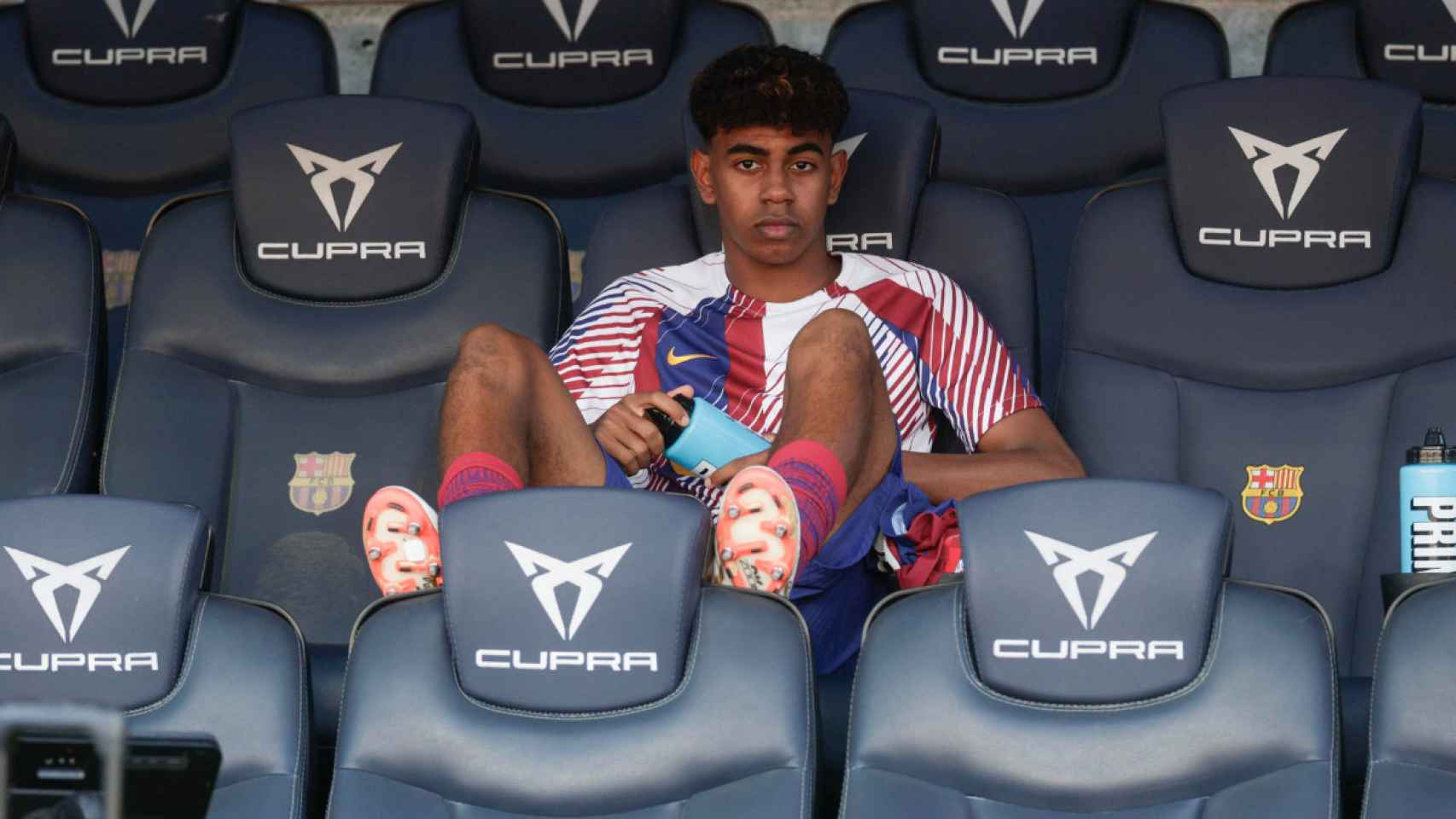 Lamine Yamal, sentado en el banquillo del Estadi Olímpic durante el partido contra el Celta