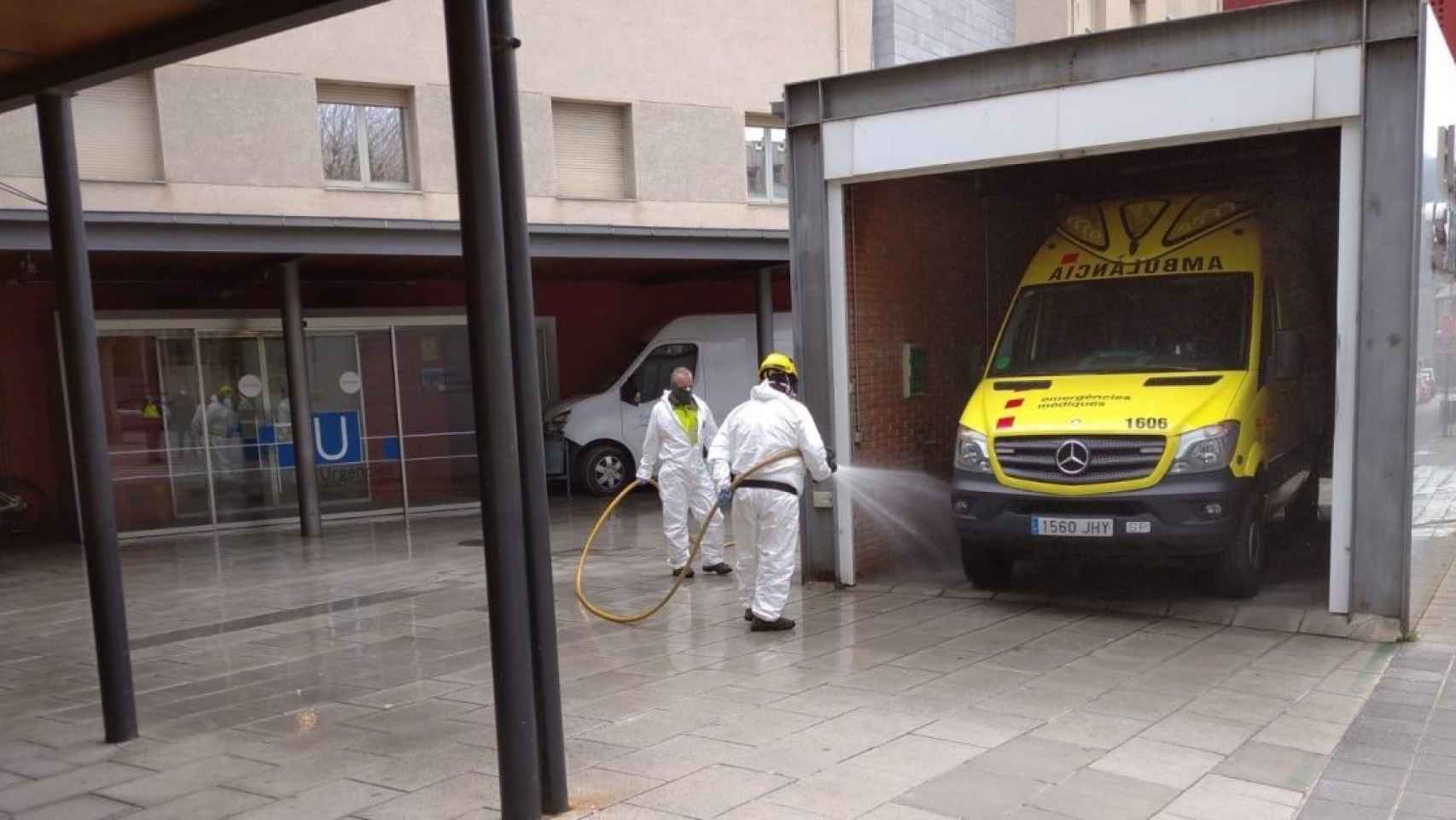 Dos sanitarios limpian una ambulancia en el Hospital de La Seu, uno de los afectados