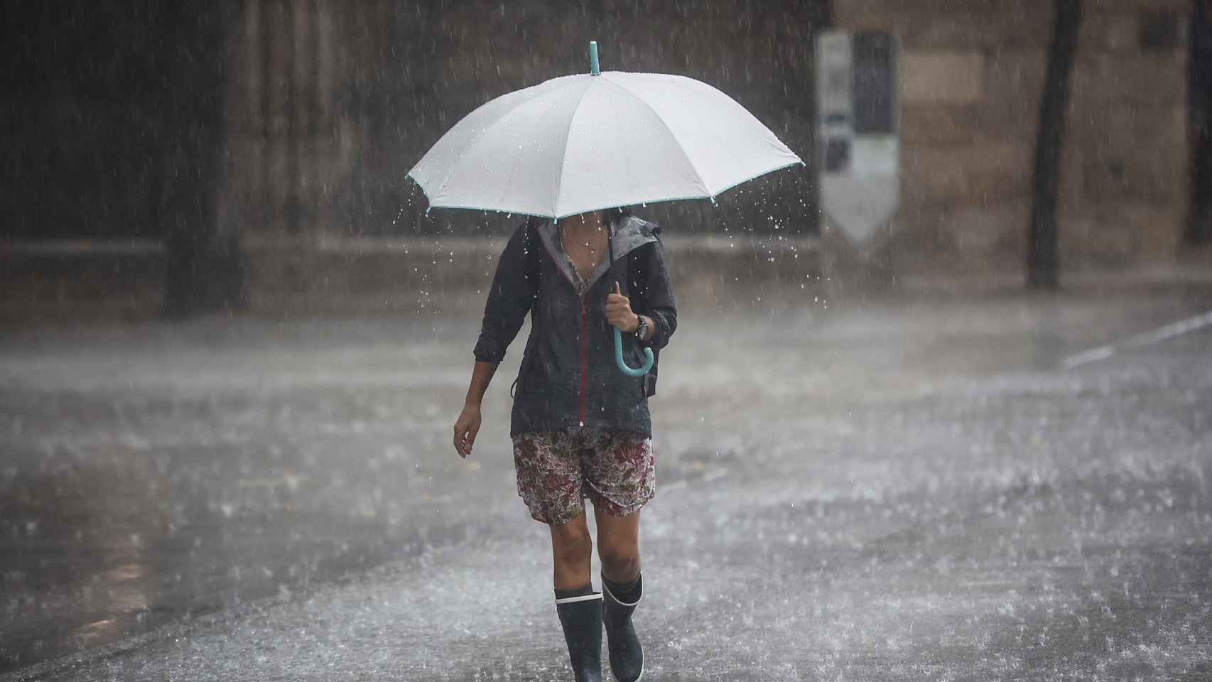 Una persona camina con paraguas bajo la lluvia