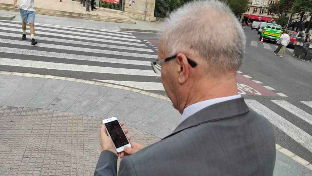 Santiago, uno de los porteros de la zona alta de Barcelona, consulta el grupo de Whatsapp con el que se comunica con sus compañeros