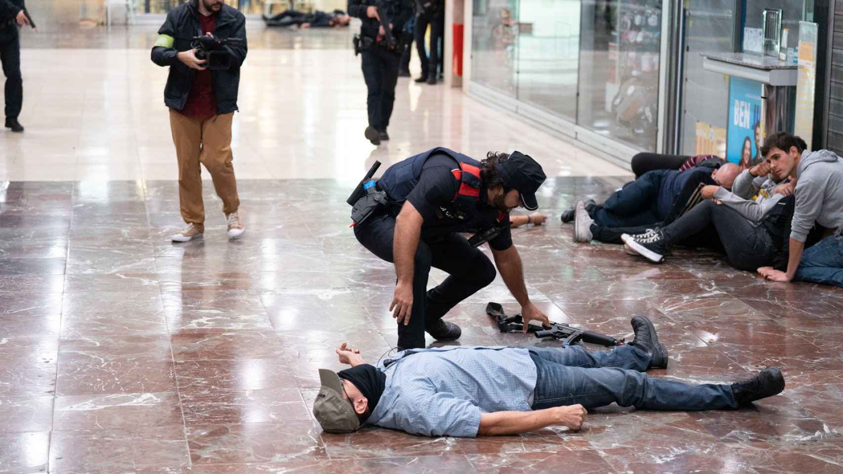Un figurante en el suelo durante el simulacro de atentado terrorista en la Estación de Sants (Barcelona)