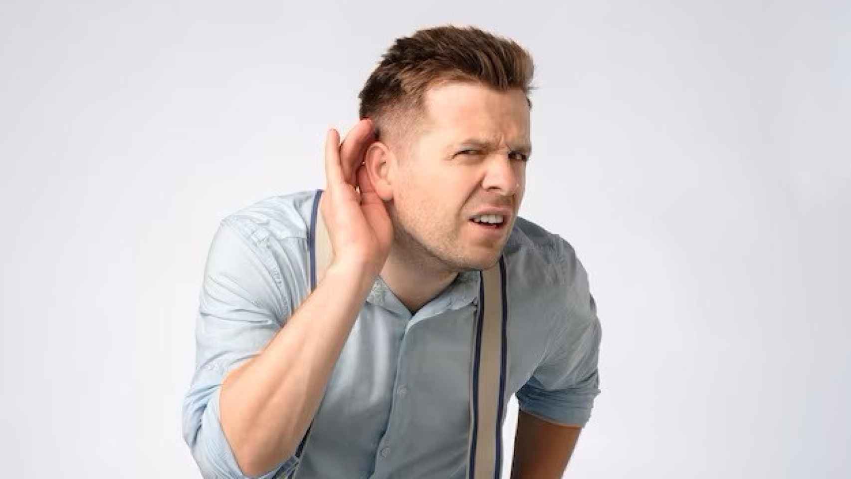 Un hombre pone atención con la oreja