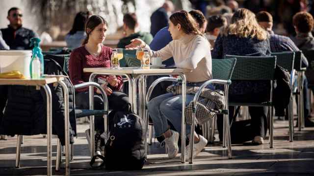 Dos personas hablan en una terraza