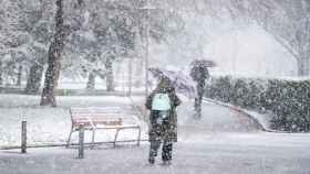 Una mujer se refugia de la nieve con un paraguas en Vitoria-Gasteiz. / EP