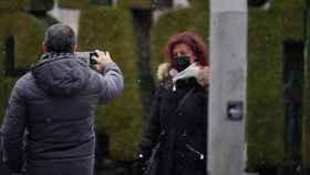 Un hombre fotografa a una mujer mientras caen copos de nieve en Vitoria / EUROPA PRESS