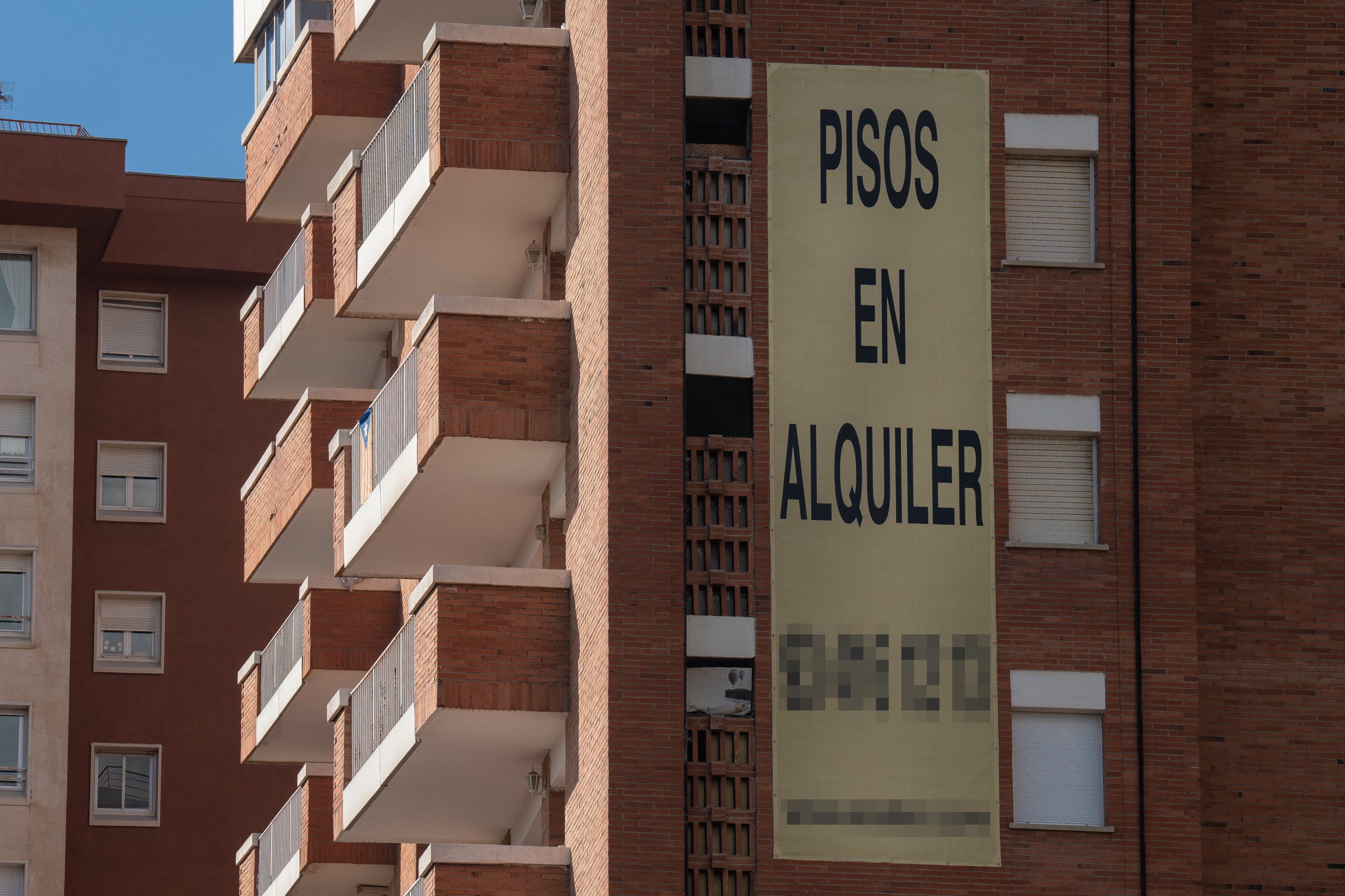 Cartel de alquiler de viviendas en la fachada de un edificio./EuropaPress