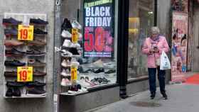Una mujer pasa por delante de una tienda que anuncia un cartel del Black Friday / EP