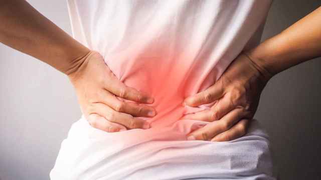Un hombre se queja de un dolor lumbar: la hernia discal es muy incapacitante / QUIRNSALUD