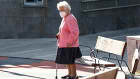 Una mujer anciana junto a un banco. / EP