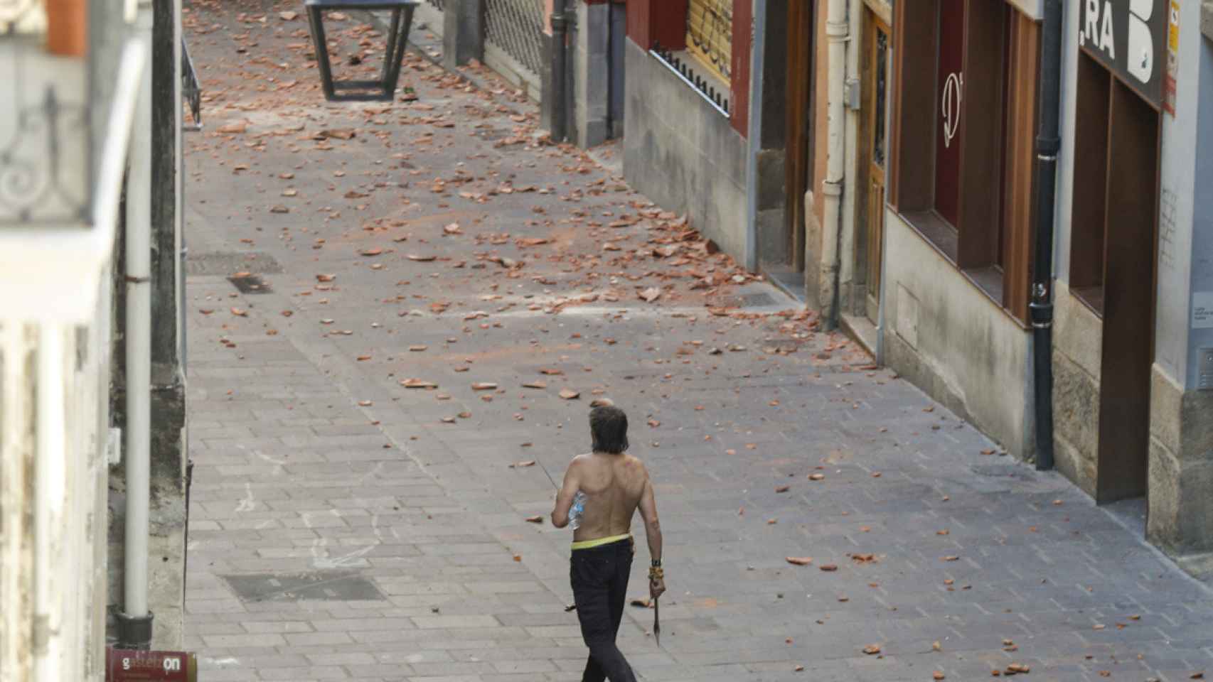 El hombre que se ha atrincherado en su piso en el Casco Viejo de Vitoria, camina por la calle armado con un hacha. / EFE/David Aguilar