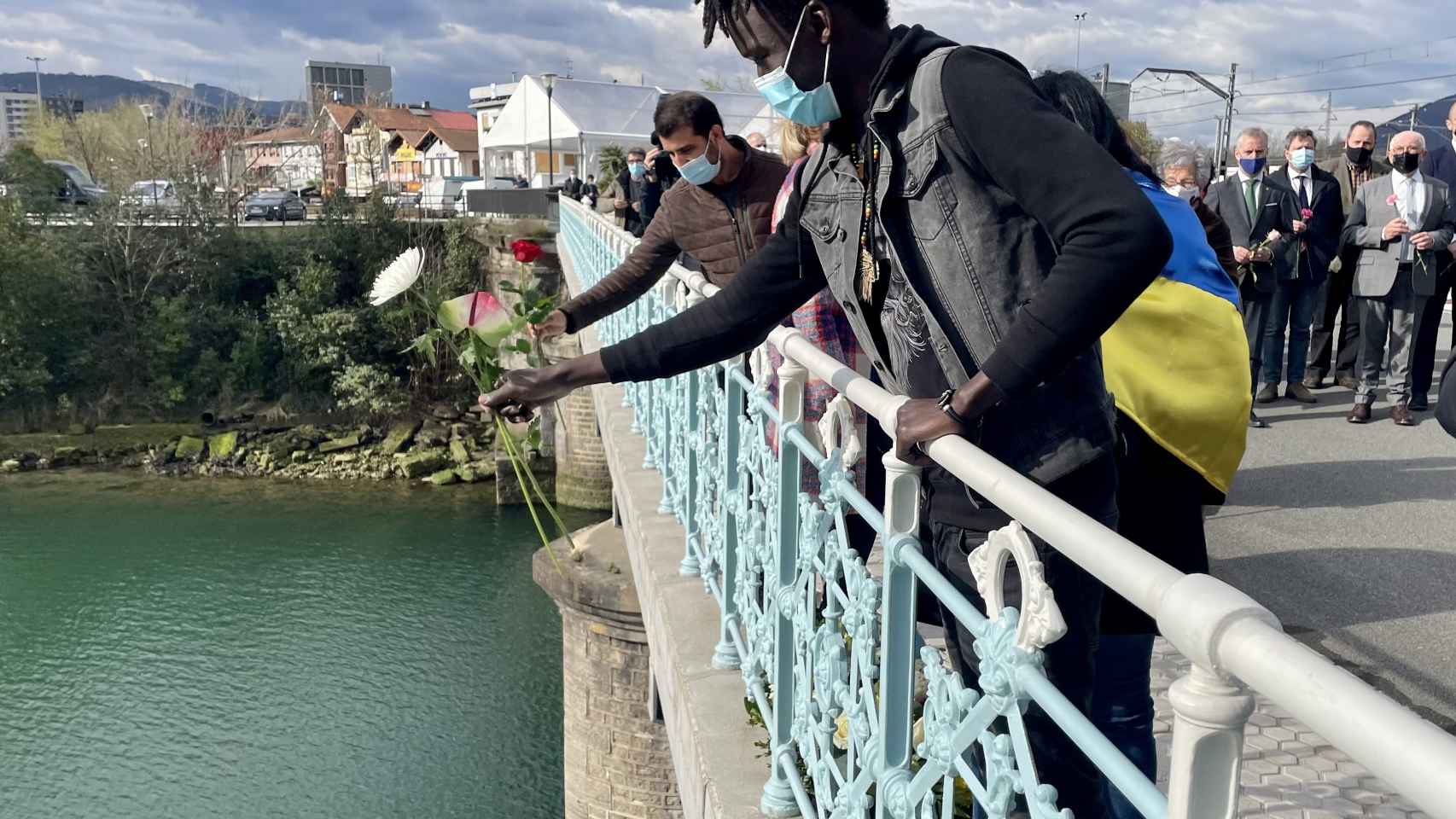 Un migrante realiza una ofrenda floral, en el ro Bidasoa, durante una concentracin para denunciar la muerte de migrantes / Europa Press