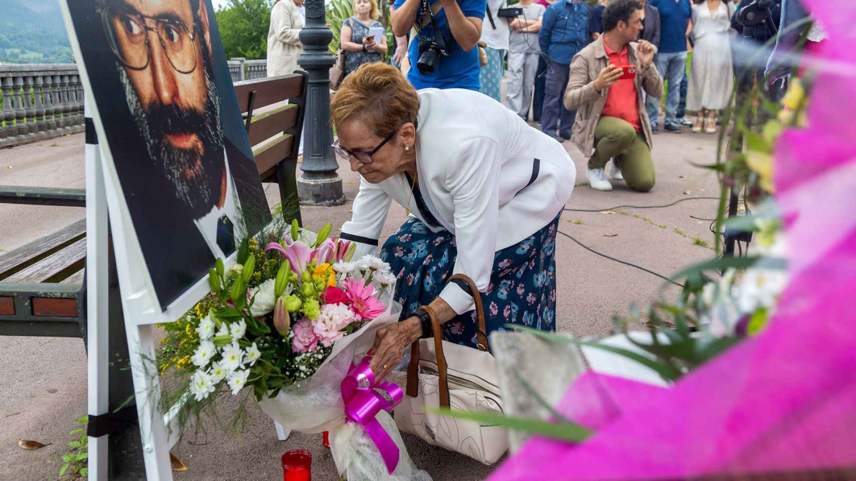 Marisol Fernández, viuda de Manuel Zamarreño, asesinado por ETA, deposita flores junto a una foto del asesinado.