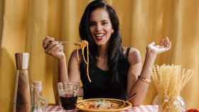 Mujer feliz disfruta de un plato de pasta
