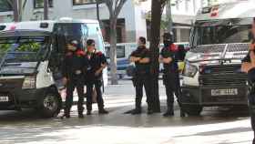 Los Mossos d'Esquadra delante de dos furgones policiales / EFE
