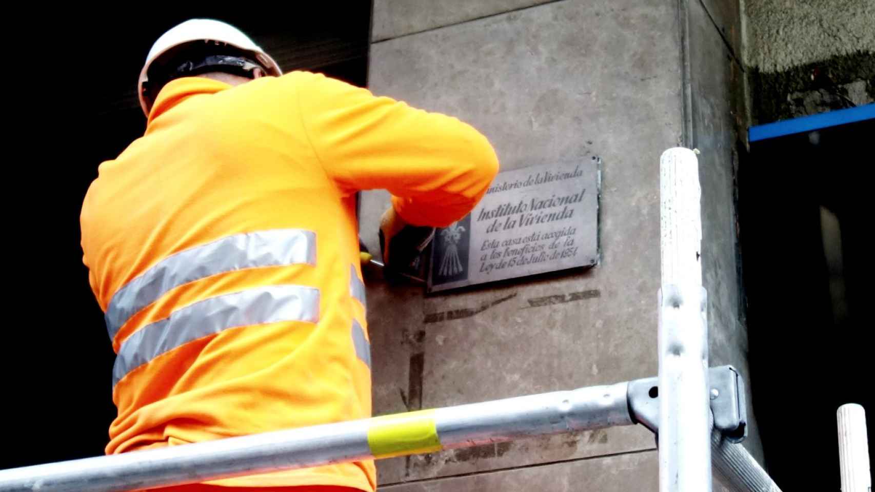 un operario retira de forma oficial la primera placa franquista de Barcelona / DGM