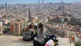 Dos turistas contemplan Barcelona hacia el mar desde el famoso mirador de los bunkers de El Carmel / Archivo