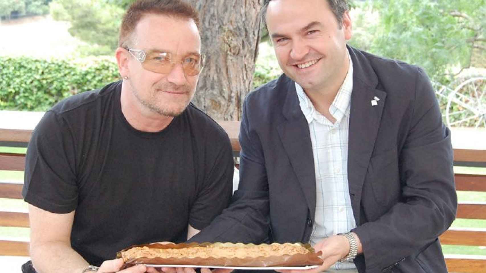 Bernat Graupera entregando una coca de Llavaneres al cantante de U2, Bono / Raquel Begines, Ajuntament de Llavaneres