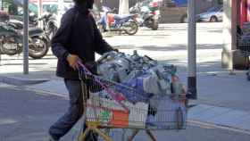 Un hombre empujando un carrito de la compra lleno de residuos / D.B.