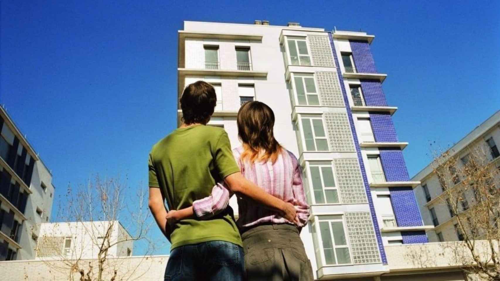 Joven pareja ante un edificio de pisos / GMG INKOPTIMIZER