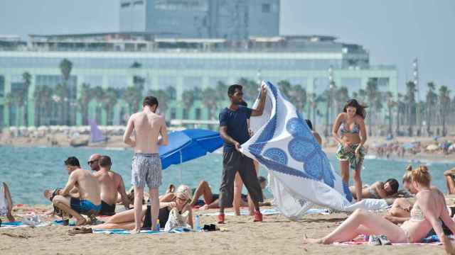 Un vendedor ambulante ofrece un pareo en la playa de Sant Miquel, en el barrio de la Barceloneta / XFDC