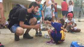 El coordinador del campamento urbano de la Trinitat Vella, Sergio Fernández, ayuda a uno de los chicos / DGM