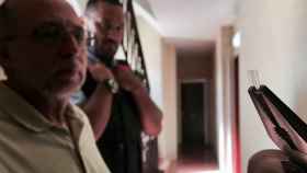 Un agente de los Mossos d'Esquadra enseña la marca de plástico que los ladrones habían puesto en el marco de la puerta / DGM