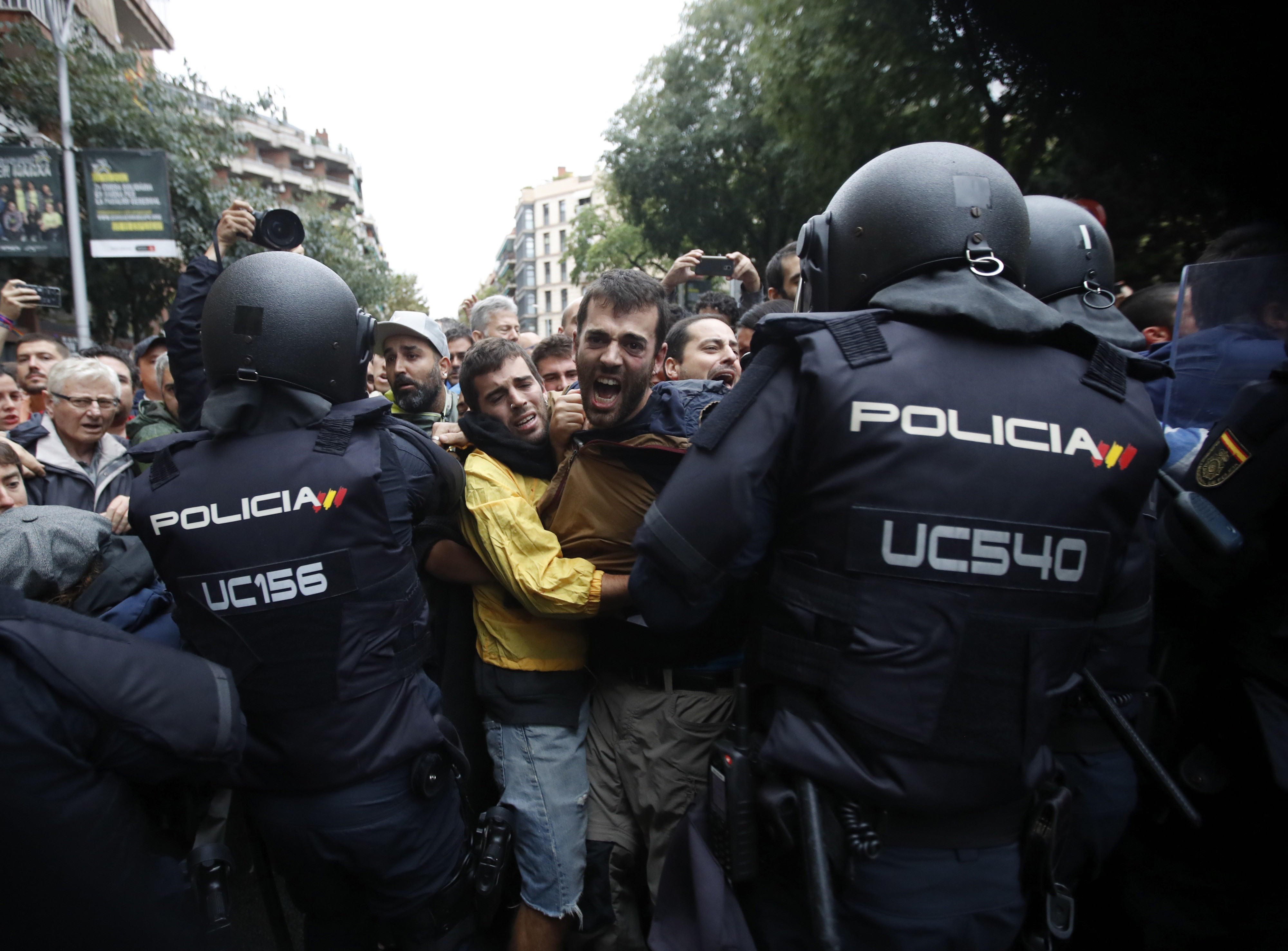 Agentes antidisturbios de la Policía Nacional forman un cordón de seguridad frente al colegio Ramón Llull/EFE/Alberto Estévez