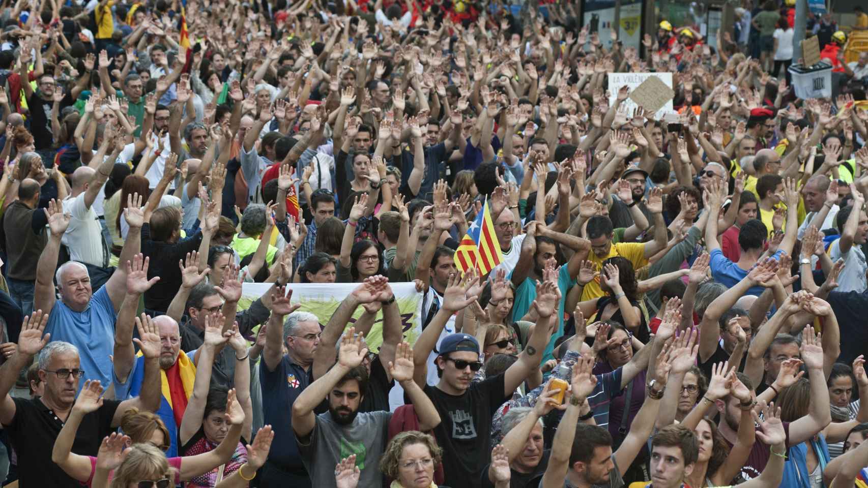 Los manifestantes levantan las manos como símbolo de su actitud pacifista / EFE