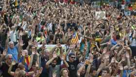Los manifestantes levantan las manos como símbolo de su actitud pacifista / EFE