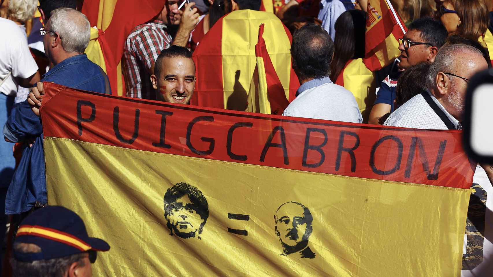 Un manifestante muestra una bandera española con alusión a Puigdemont / EFE/Alejandro García