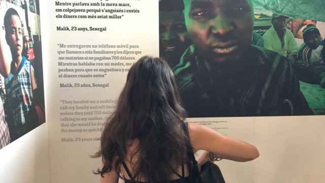 Una joven mira la exposición 'Éxodo, vida y muerte en la ruta libia hacia Europa / PABLO ALEGRE