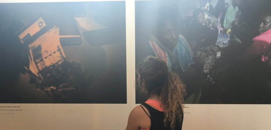 Una joven mira la exposición 'Éxodo, vida y muerte en la ruta libia hacia Europa' / PABLO ALEGRE