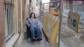 Assumpta Cavanillas, en silla de ruedas, en el pasaje de Roura, en el Clot Camp de l'Arpa / JORDI SUBIRANA