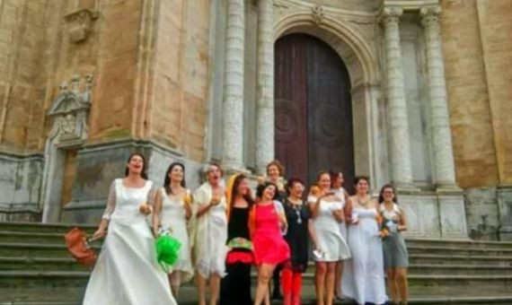 Las novias a punto de casarse consigo mismas frente la catedral en Cádiz