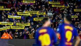 Messi y Suárez, con varias banderolas al fondo a favor de la libertad de los presos / EFE