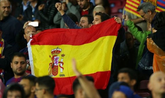 Un aficionado del Barça exhibe una bandera española en el Camp Nou