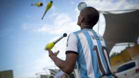 Un joven haciendo malabares con la camiseta de la selección de fútbol argentina / EFE