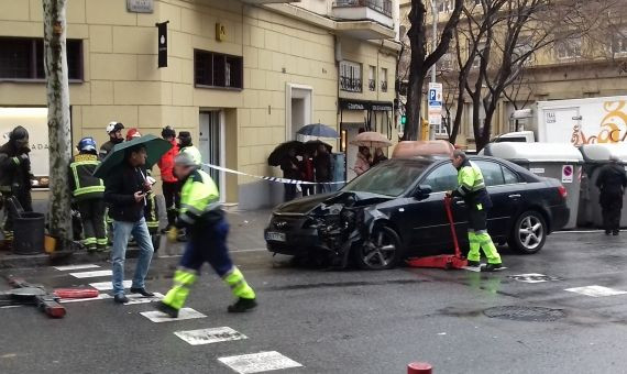 Operarios municipales retiran el coche tras el aparatoso accidente, este lunes en el Eixample / JORDI SUBIRANA