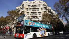 Un autobús turístico pasa por delante de La Pedrera, en la confluencia entre Paseo de Gràcia y calle Provença / TMB