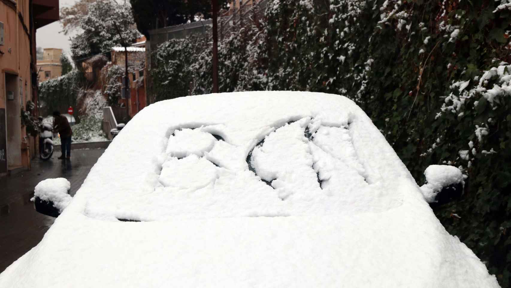Un coche cubierto por la nieve en Barcelona, el pasado mes de febrero. La próxima semana podría volver a caer / HUGO FERNÁNDEZ
