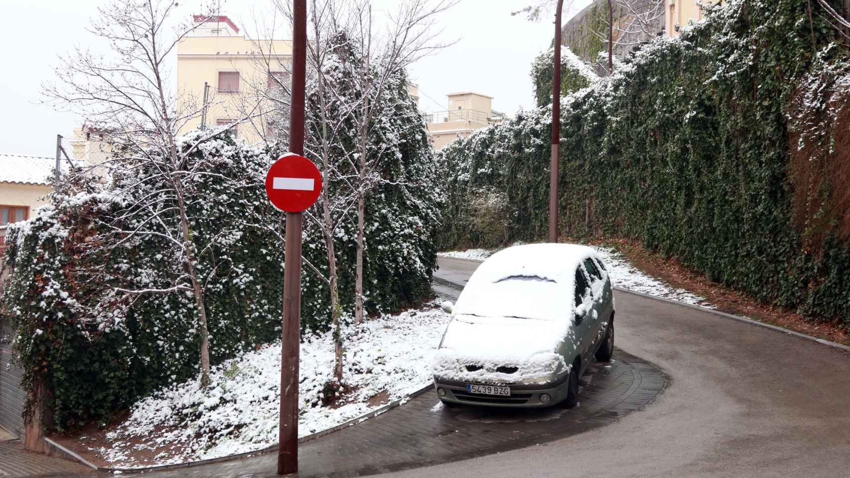 Un coche cubierto por la nieve y circulando por Barcelona / ÁLVARO VENTURA