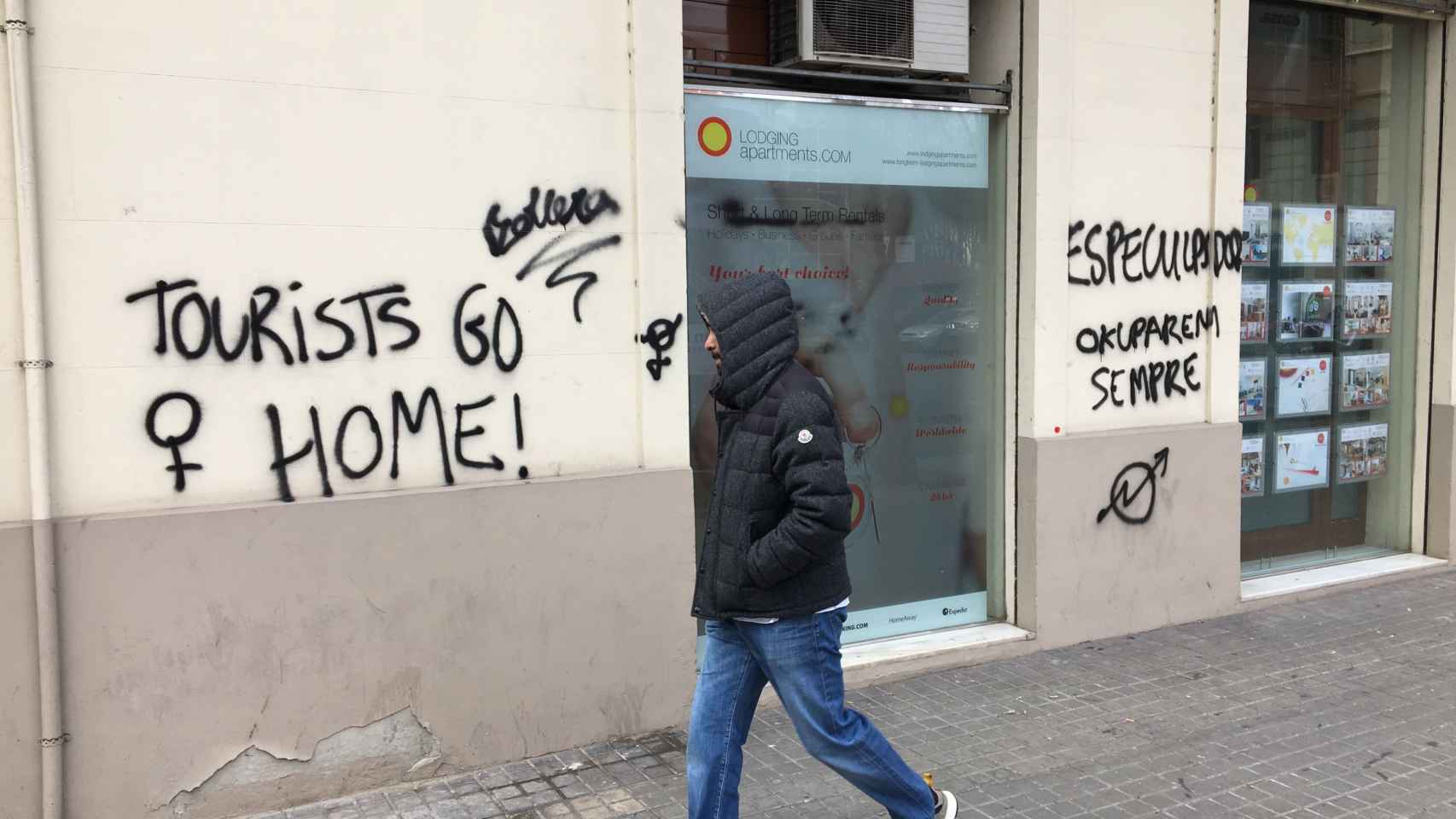 Pintadas del movimiento okupa en contra del turísmo en la fachada de una agencia de apartamentos turísticos de la calle de Aragó / XAVIER ADELL