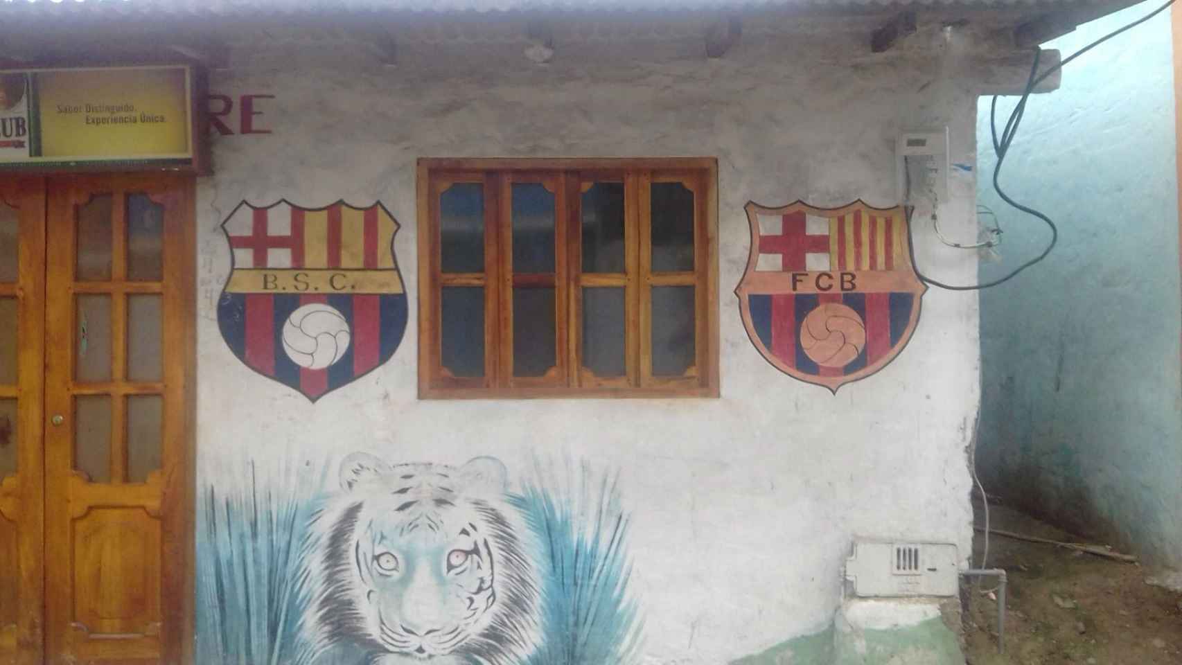 Los dos escudos de los equipos pintados en una fachada del pueblito costero Olón / PAULA BALDRICH