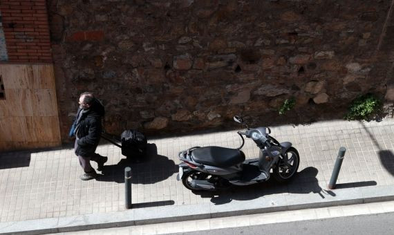Una moto mal aparcada en una acera de menos de tres metros de Gràcia / HUGO FERNÁNDEZ