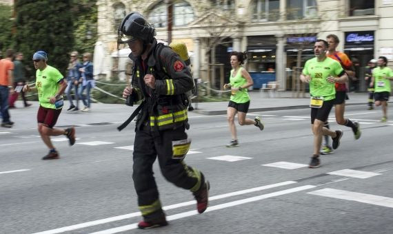 Un bombero, cargado con una bombona de oxígeno, en Via Laietana / HUGO FERNÁNDEZ