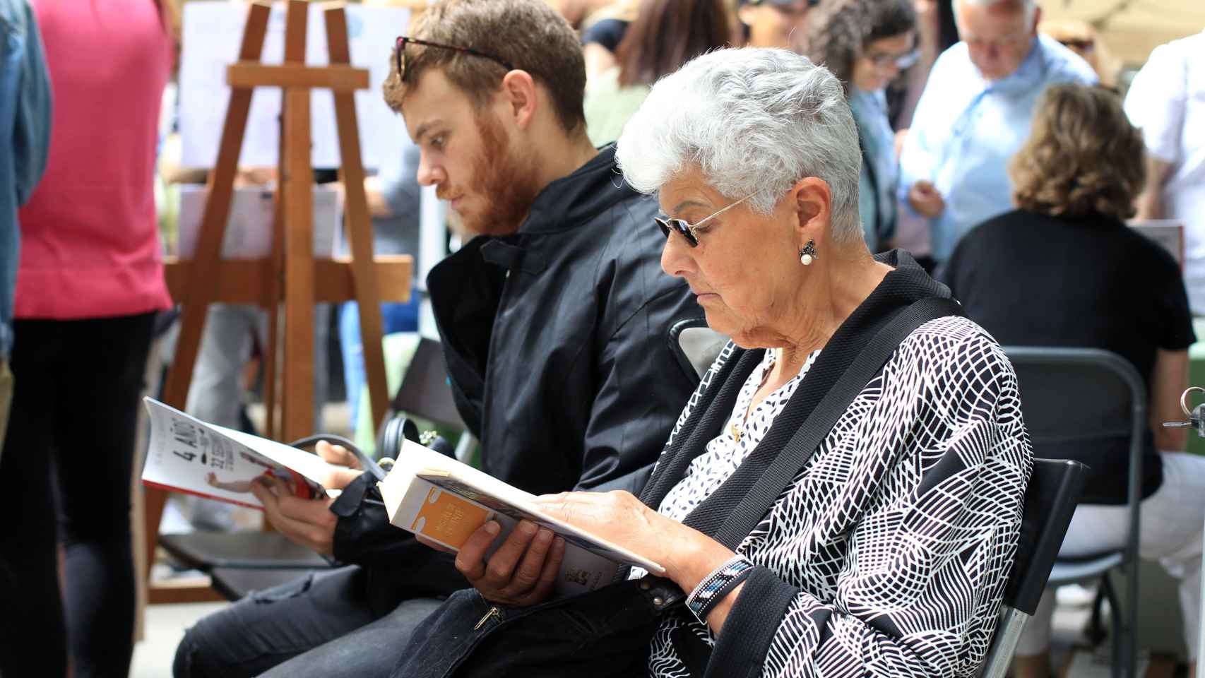 Una señora y un hombre leyendo libros en Sant Jordi | HUGO FERNÁNDEZ