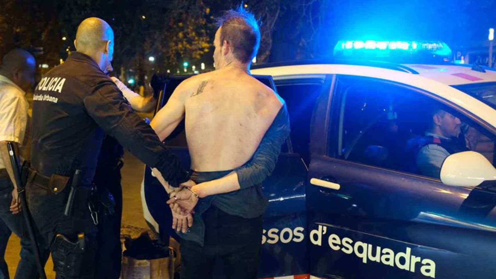 Momento en que el presunto agresor es introducido en un coche de los mossos / Vicens Forner