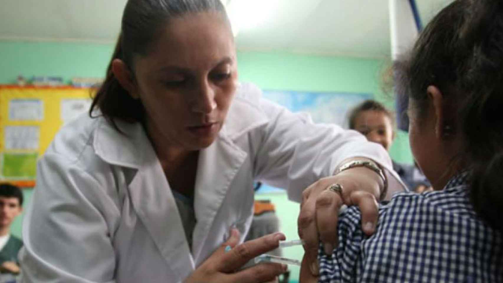 Una enfermera vacuna a una niña