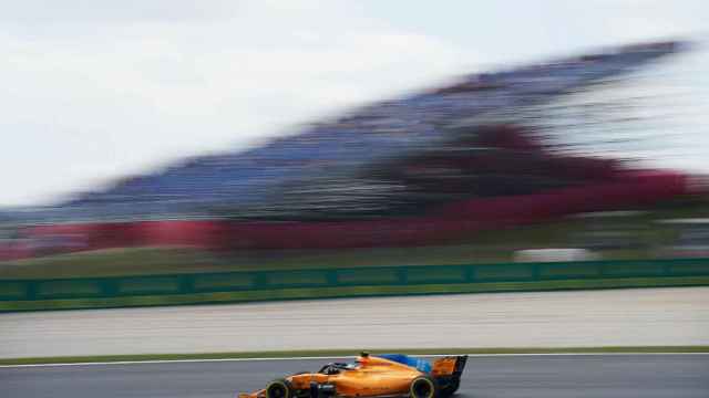 El McLaren de Fernando Alonso parece congelado mientras sobrepasa la tribuna principal del circuito de Montmeló / EFE, Alejandro García