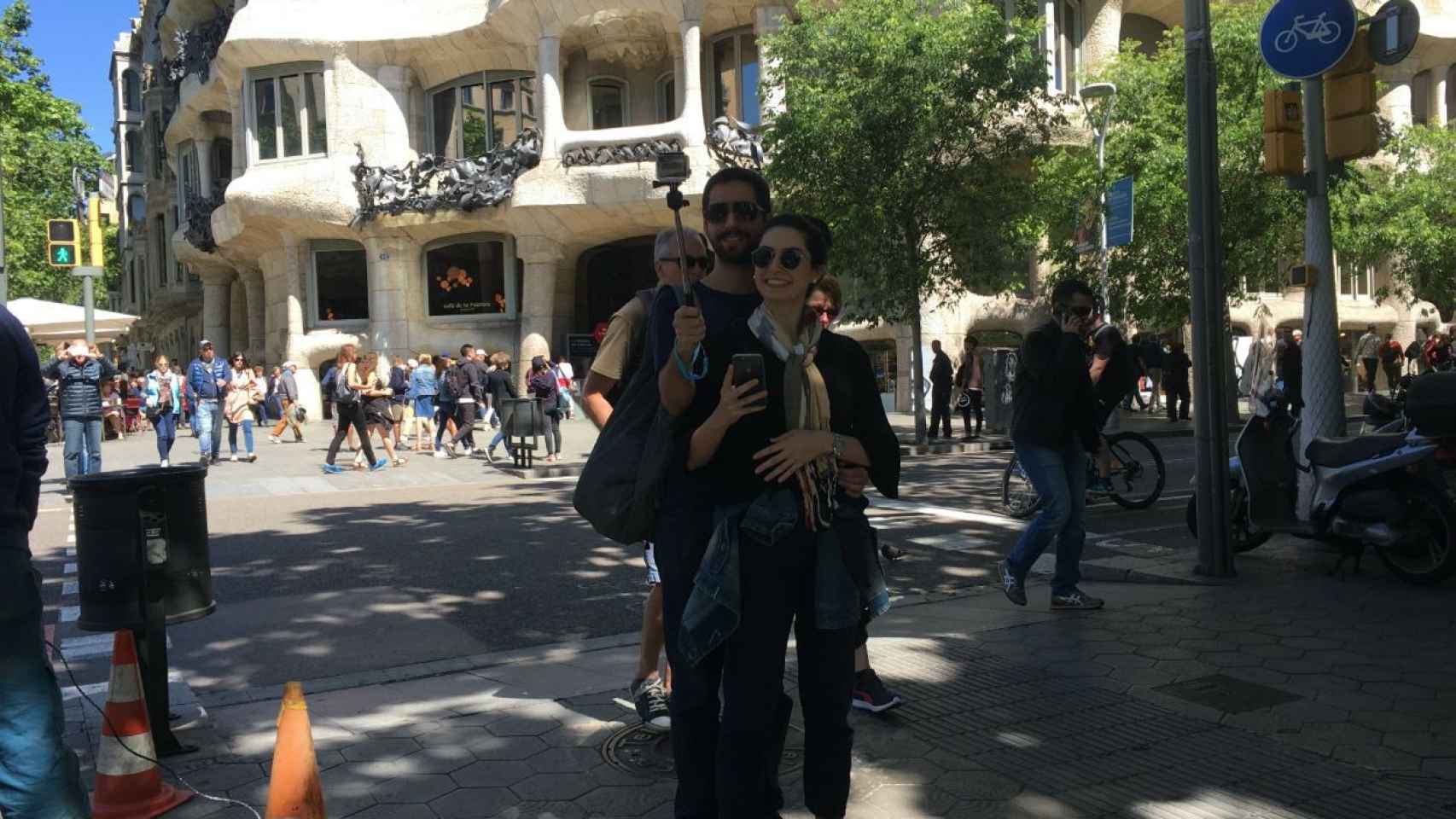Una pareja de turistas haciéndose un selfie frente a La Pedrera | PAULA BALDRICH